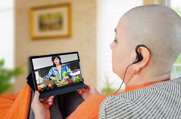 woman missing her hair looking at an online cooking class
