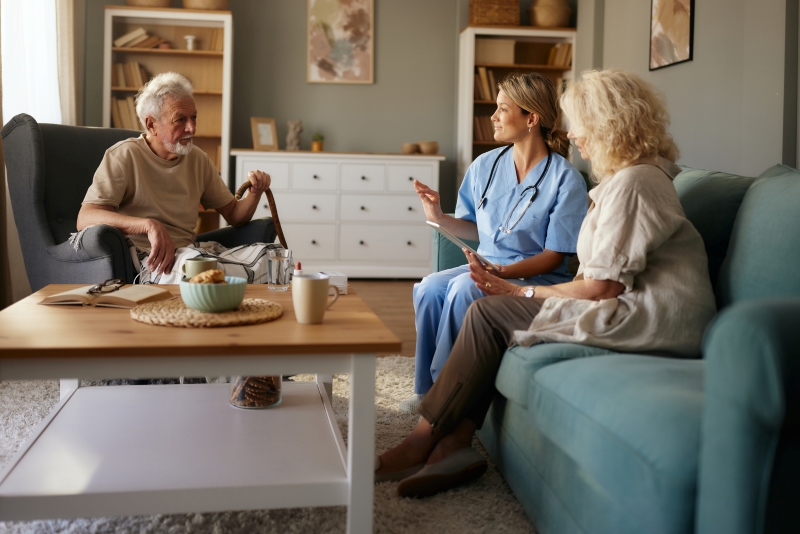 Older man and woman sitting and speaking with a provider