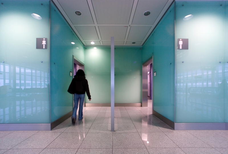 A lady walking into a women's bathroom