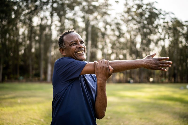 Older black man stretching outdoors